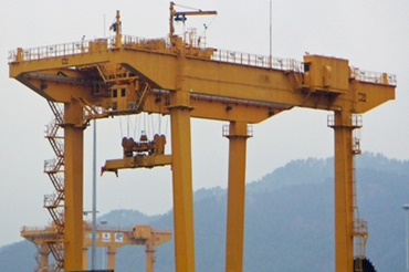 Grúa apiladora sobre raíles (RMG) con cadenas portacables y cables chainflex® de igus®