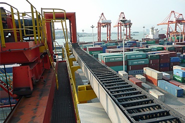 Grúa apiladora de contenedores sobre neumáticos (RTG) con una cadena portacables y cables chainflex® de igus®